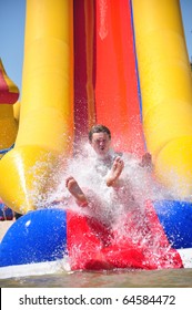 Young Man Riding Down A Water Slide