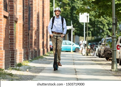 Young Man Riding An Electric Kick Scooter