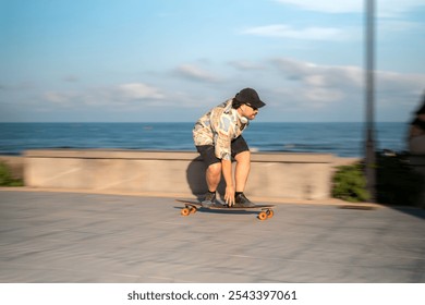 Young man riding a longboard on a promenade by the sea - Powered by Shutterstock