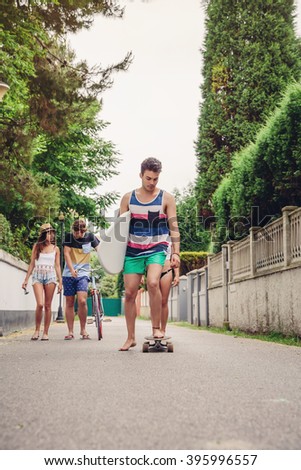 Similar – Young man riding on skate and holding surfboard