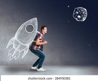 Young man with a rocket on his back - Shutterstock ID 284930381