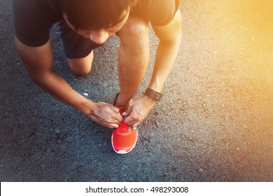 Young Man Runner Tying Shoelaces