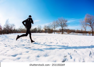 Young Man Running During Winter At Park