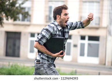 Young Man Running Late For His Meeting, Looks At The Time On His Watch, Feeling Stressed And Sprinting To His Meeting