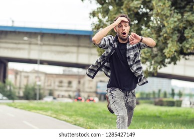 Young Man Running Late For His Meeting, Looks At The Time On His Watch, Feeling Stressed And Sprinting To His Meeting