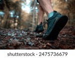 Young man running off road on a forest trail. Close up shot.