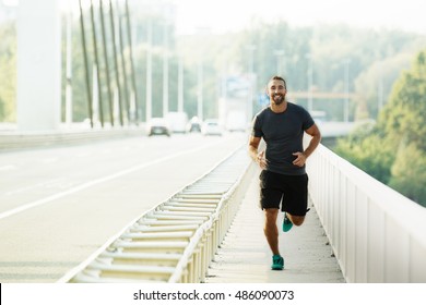 Young Man Running On The Bridge. 