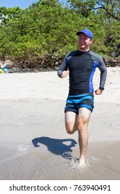 Young Man Running On The Hot Sand With An Obvious Tan Line On His Legs