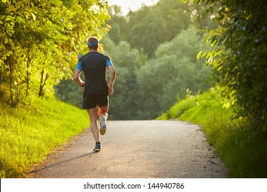 Young Man Is Running On Road - Sunset Back Lit