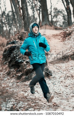 Young man running outdoors during workout in a forest