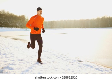 Young Man Running At Winter In Park