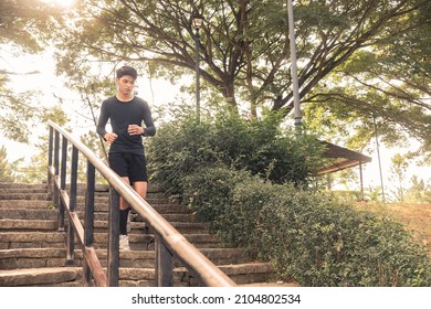 A Young Man Runs Down A Flights Of Steps At A Downhill Slope. Outdoor Exercise Scene.