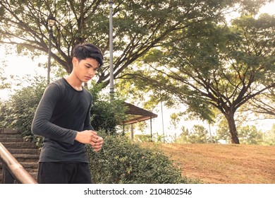 A Young Man Runs Down A Flights Of Steps At A Downhill Slope. Outdoor Exercise Scene.