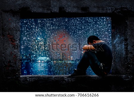 The young man sat facing the window on a beautiful night of rain.