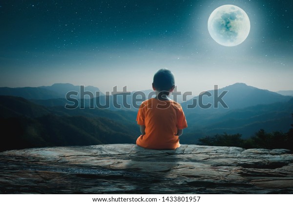 若い男は寂しい夜に岩の崖の上で満月を見つめて座った の写真素材 今すぐ編集