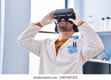 Young man scientist using virtual reality goggles at laboratory