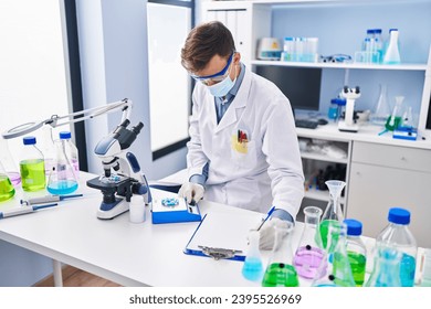 Young man scientist wearing medical mask weighing pills at laboratory - Powered by Shutterstock