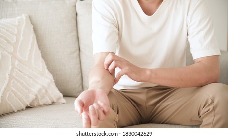 Young Man Is Scratching His Arm