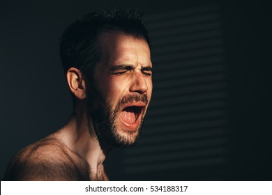 Young Man Screaming And Crying In The Dark