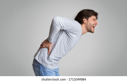 Young Man Screams In Pain In His Back. Muscle Pain, Kidney Pain.