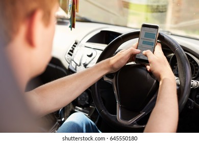 Young Man Sending Text Message Whilst Driving