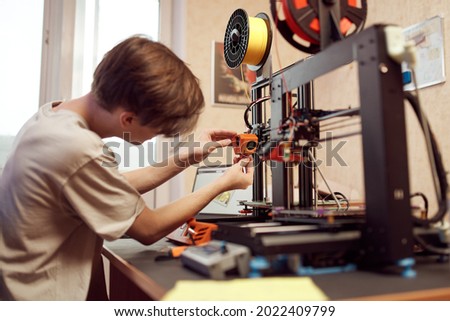 Young man set up 3d printer