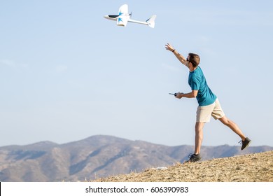 Young Man Setting Remote Control Plane In Air
