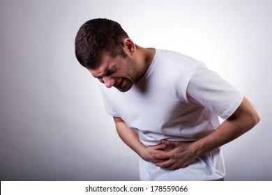 Young Man With Severe Stomachache Holding His Stomach