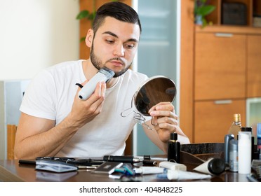 Young Man Shaving His Beard With A Trimmer