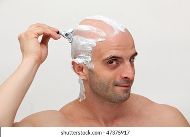 Young Man Shaving His Head With Razor Blade