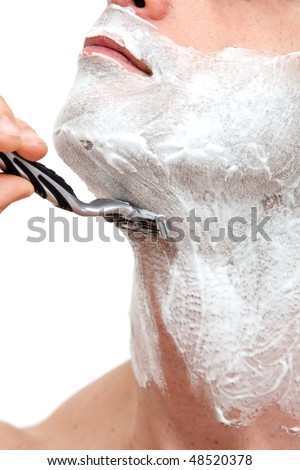 Young man shaving with a razorblade