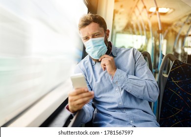 Young man in a shirt with a protective mask on his face sitting on the bus and using a mobile phone to send a text. 