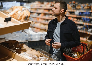 Young man shopping in grocery store. Shopping concept. - Powered by Shutterstock