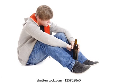 Young man with short blond hair sitting on the floor with beer bottles and is drunk, isolated against white background