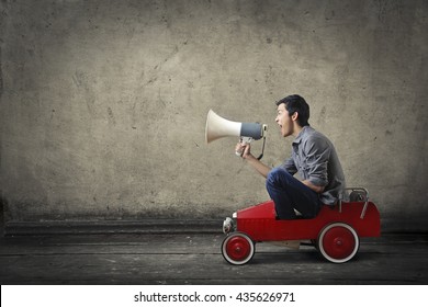 Young Man Shouting From A Toy Car