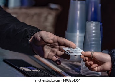 Young Man Show Valid ID To Buy Alcohol And Cigarettes In Pub Photographed With Shallow Depth Of Field