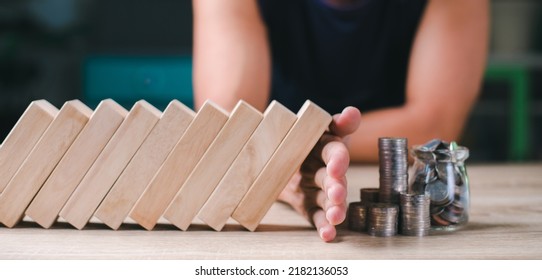 Young man showing defense, finance, investment by blocking a stick. which is like risk, crisis, bankruptcy, change Keep the coin pile safe. Savings Ideas and Strategies That Are Safe for Businesses - Shutterstock ID 2182136053