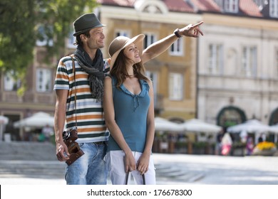 Young Man Showing Something To Woman During Vacation