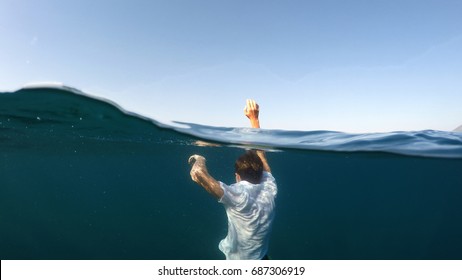 young man sinking into the sea