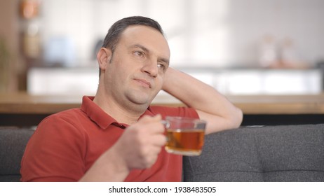 Young Man Sitting Alone At Home Drinking Herbal Tea. Portrait Of Man Drinking Herbal Tea.