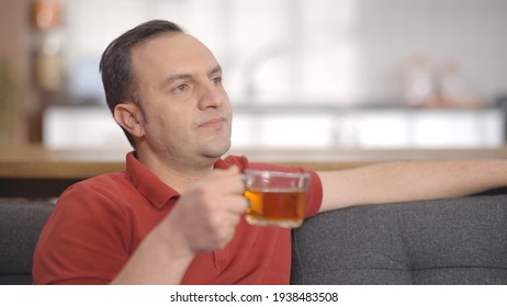 Young Man Sitting Alone At Home Drinking Herbal Tea. Portrait Of Man Drinking Herbal Tea.