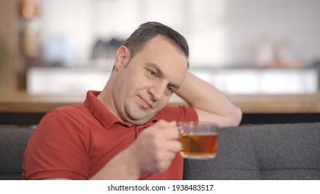 Young Man Sitting Alone At Home Drinking Herbal Tea. Portrait Of Man Drinking Herbal Tea.