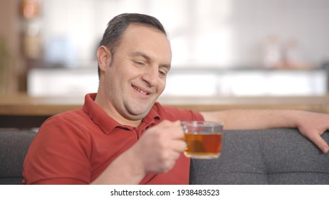 Young Man Sitting Alone At Home Drinking Herbal Tea. Portrait Of Man Drinking Herbal Tea.