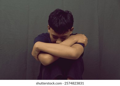A young man sitting alone, hugging his knees, portraying emotional struggle and sadness. This image represents mental health challenges, depression, and the need for support and awareness. - Powered by Shutterstock - Get 15% off with code: PIKWIZARD15
