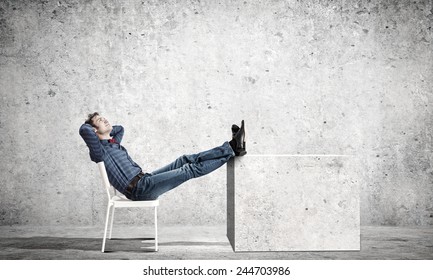 Young Man Sitting In Chair With Legs Up And Relaxing