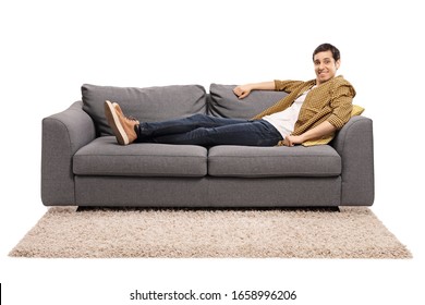 Young Man Sitting Comfortably On A Sofa Isolated On White Background