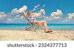 Young man sitting at a deck chair by the sea