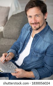 Young Man Sitting Doing A Crossword Puzzle