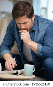 Young Man Sitting Doing A Crossword Puzzle