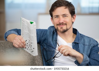 Young Man Sitting Doing A Crossword Puzzle